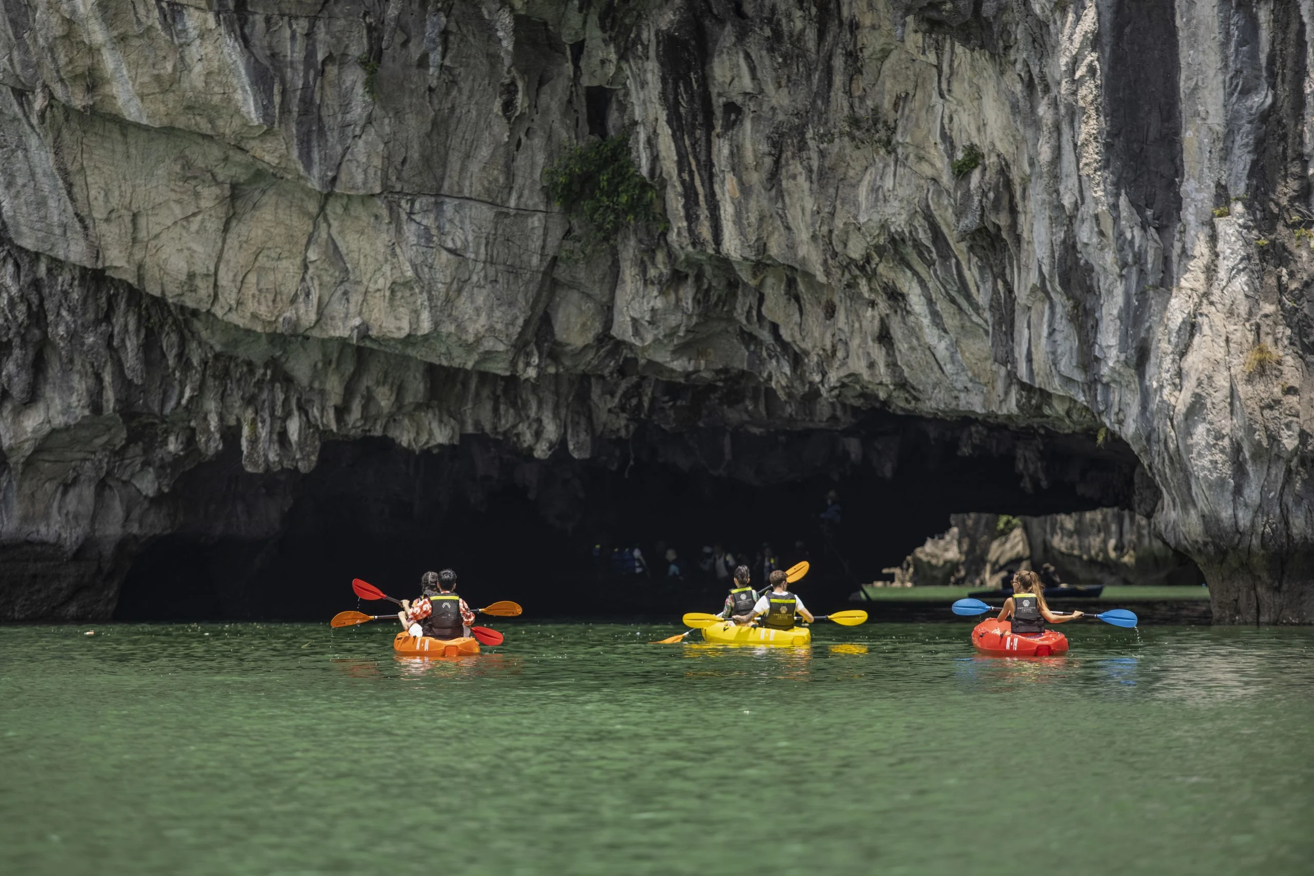 Kayaking through Luon Cave arch into hidden lagoon Ha Long Bay
